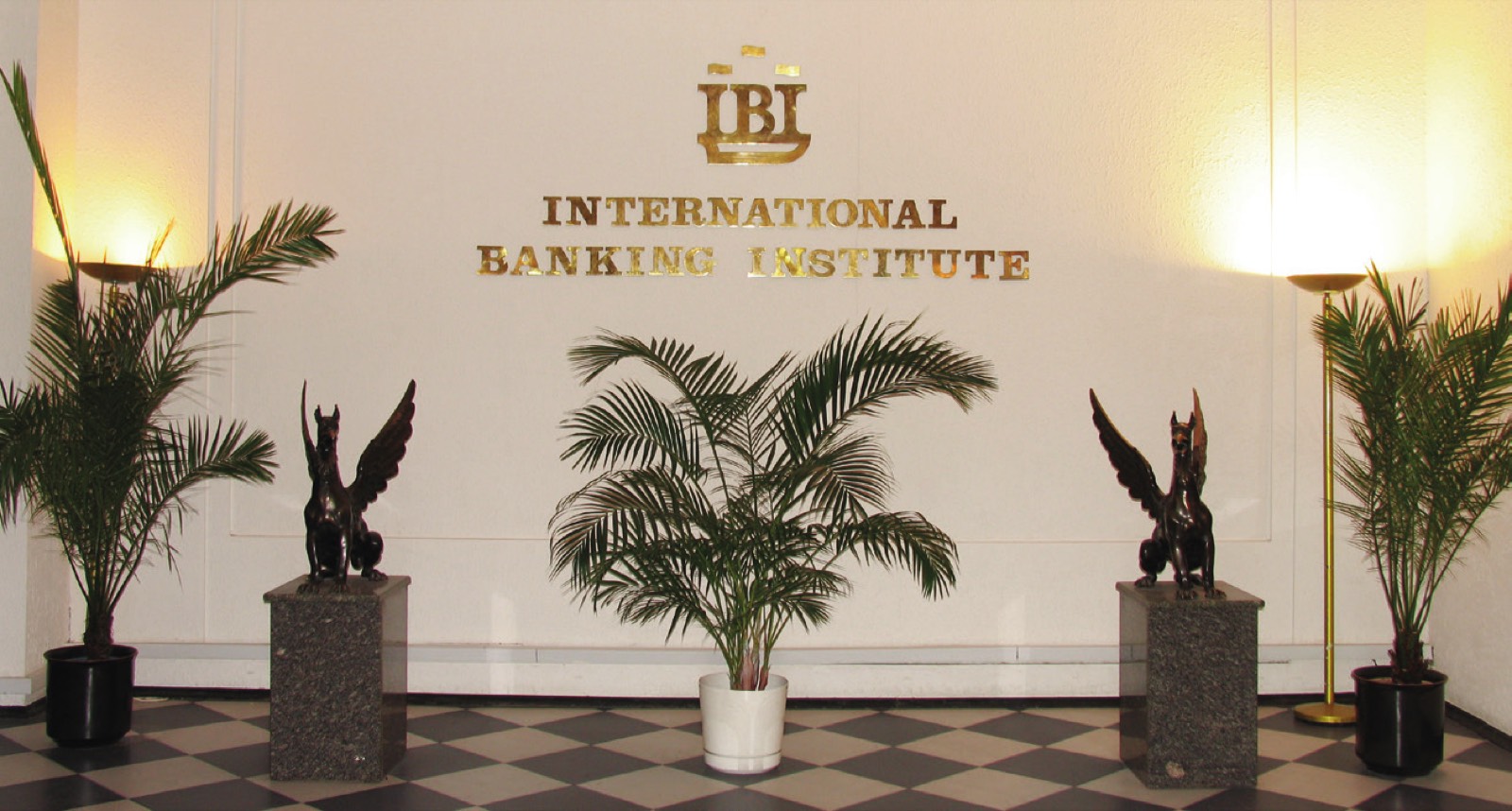 Холл МБИ с эмблемой International Banking Institute и парой грифонов на постаментах